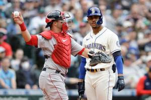 Boston Red Sox catcher Kevin Plawecki, left, returns the ball as Seattle Mariners' Julio Rodriguez reacts to striking out on a pitch from Red Sox starter Kutter Crawford during the third inning of a baseball game, Sunday, June 12, 2022, in Seattle. (AP Photo/John Froschauer)
