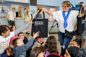 Cassie Franklin, mayor of Everett, hands out laptops to kids at the South Everett/Mukilteo Boys & Girls Club in Everett, Washington on Wednesday morning, June 22, 2022.  The laptops are part of Comcast Digital Equity Initiative that will give away 400 laptops. (Kevin Clark / The Herald)