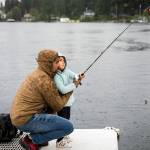 Ridley Biggs, 5, right, learns how to cast with her father Mike Biggs as it starts to rain on Friday, June 17, 2022 in Lake Stevens, Washington. (Olivia Vanni / The Herald)