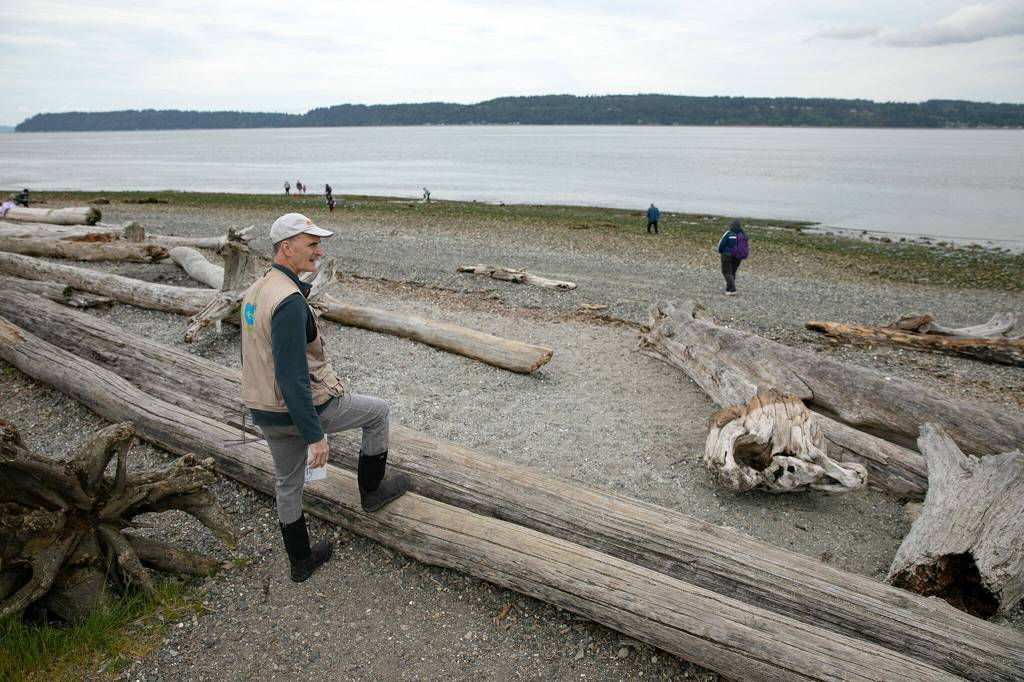 Tim Ellis, a WSU Beach Walker, watches as the water continues to go out during the lowest tide in over a decade Wednesday at Lighthouse Park in Mukilteo. (Ryan Berry / The Herald)