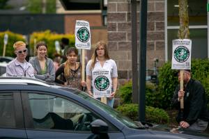 Striking Starbucks employees talk to a woman who wanted to use the drive-thru but was turned away due to the strike on Wednesday, June 15, 2022, on Broadway in Everett, Washington. Workers at the 37th and Broadway store spent their morning picketing because a fellow employee had been fired the previous day in what the workers believe is an act of union busting. (Ryan Berry / The Herald)