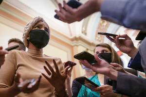 Reporters gather around Rep. Ilhan Omar, D-Minn., outside the House chamber during a vote on the John Lewis Voting Rights Advancement Act, named for the late Georgia congressman who made the issue a defining one of his career, at the Capitol in Washington, Tuesday, Aug. 24, 2021. (AP Photo/J. Scott Applewhite)