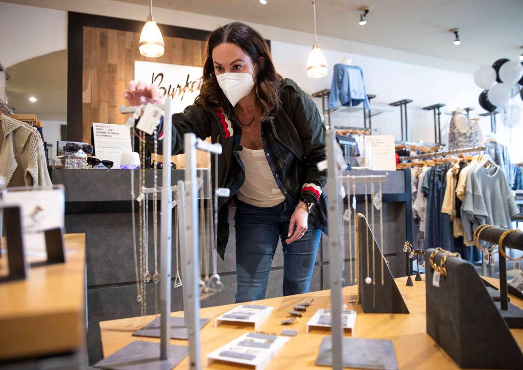 Lisa Richardt, the owner and creator of Veronica & Harold jewelry, adjusts her display inside Burketts Home & Gift on Friday in Everett. (Olivia Vanni / The Herald)