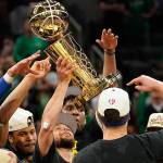Warriors guard Stephen Curry (center) holds up the Larry OBrien Championship Trophy with teammates after defeating the Celtics in Game 6 of NBA Finals on Thursday in Boston. (AP Photo/Steven Senne)