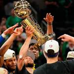 Golden State Warriors guard Stephen Curry, center, holds up the Larry O'Brien Championship Trophy with teammates after defeating the Boston Celtics in Game 6 of basketball's NBA Finals, Thursday, June 16, 2022, in Boston. (AP Photo/Steven Senne)