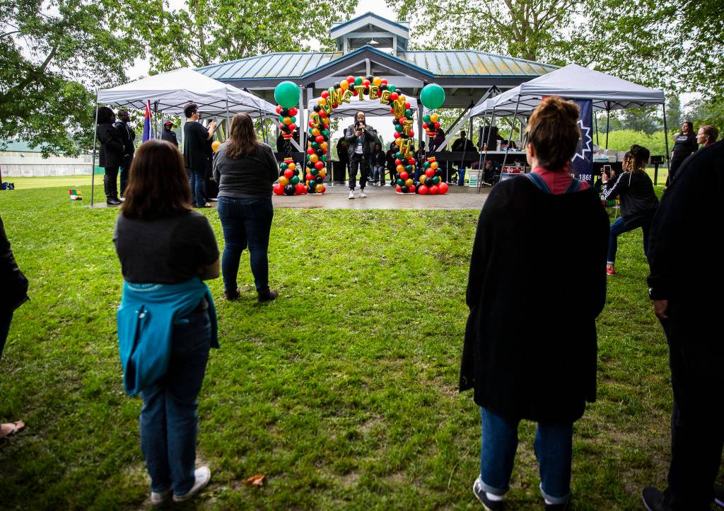 People gather to listen to Raylin Lucey read his spoken word poem Safe during Monroes Juneteenth celebration Saturday. (Olivia Vanni / The Herald)