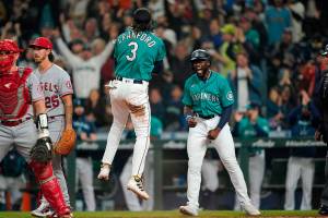 Seattle Mariners' J.P. Crawford (3) celebrates with Taylor Trammell, right, after they both scored on a three-run double hit by Ty France during the fourth inning of a baseball game against the Los Angeles Angels, Friday, June 17, 2022, in Seattle. (AP Photo/Ted S. Warren)