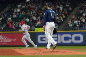 Seattle Mariners pitcher Tommy Milone (53) watches as Los Angeles Angels' Mike Trout runs the bases on a solo home run during the third inning of the second baseball game of a doubleheader Saturday, June 18, 2022, in Seattle. (AP Photo/Ted S. Warren)