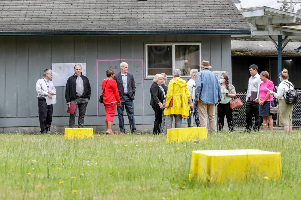 Officials tour the site of the proposed Faith Family Village on Wednesday at Faith Lutheran Church in Everett. (Kevin Clark / The Herald)