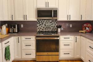 After: Granite Transformations’ environmentally friendly engineered stone countertop and backsplash in Pietra del Cardoso adds a modern look to this kitchen.