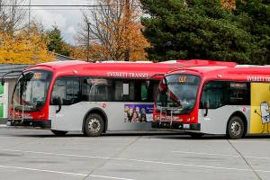 Buses charge before their next route Friday afternoon at the Everett Transit Center in Everett on October 22, 2021.  (Kevin Clark / The Herald)