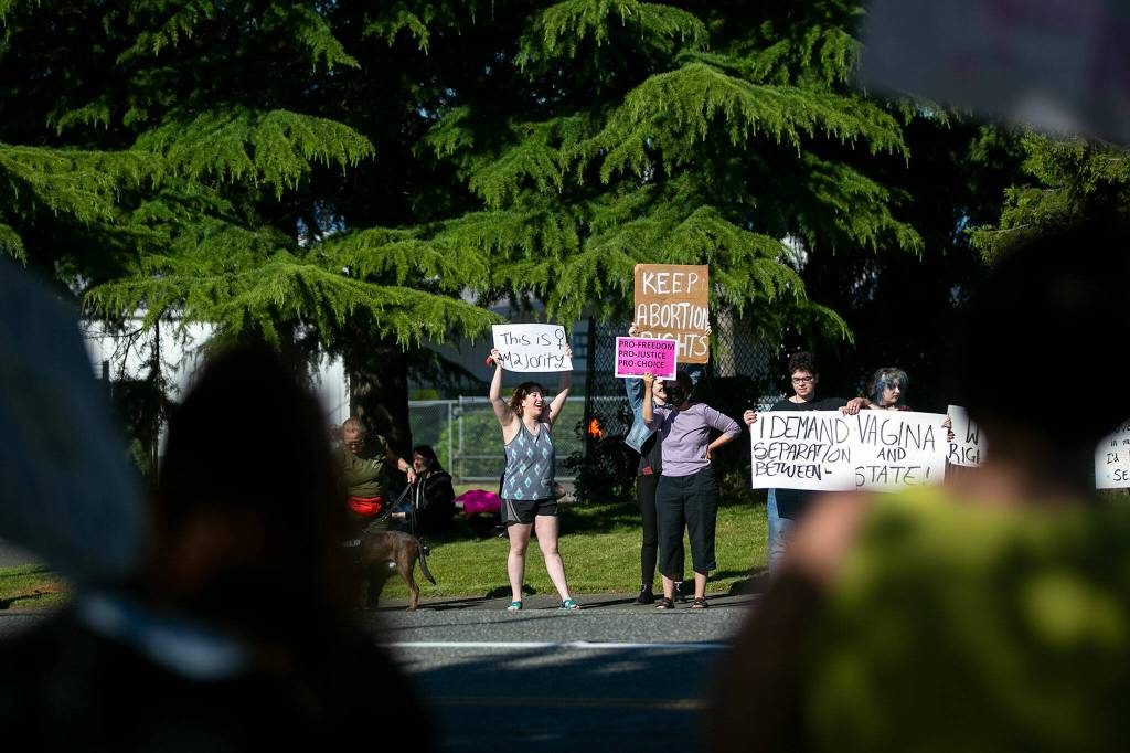 People begin to line the far side of the street during a protest against the Supreme Courts decision to overturn Roe v. Wade on Friday along Broadway in Everett, Washington. (Ryan Berry / The Herald)