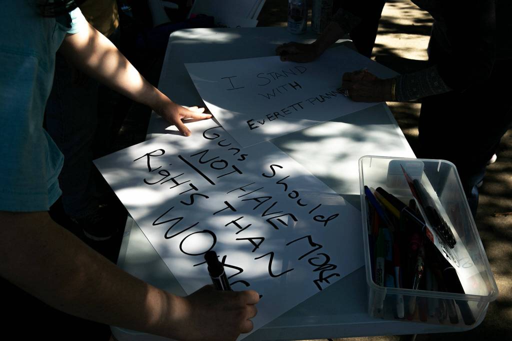 People make signs to hold during a protest against the Supreme Courts decision to overturn Roe v. Wade on Friday along Broadway in Everett, Washington. (Ryan Berry / The Herald)