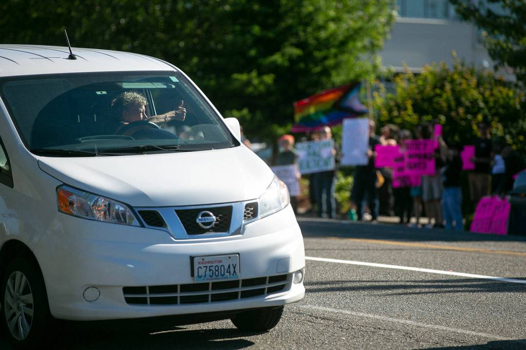 A passing driver gives a thumbs up to demonstrators during a protest against the Supreme Courts decision to overturn Roe v. Wade on Friday along Broadway in Everett, Washington. (Ryan Berry / The Herald)