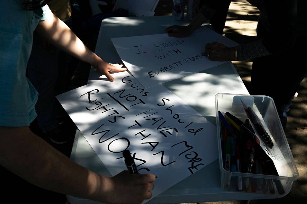 People make signs to hold during a protest against the Supreme Courts decision to overturn Roe v. Wade on Friday along Broadway in Everett, Washington. (Ryan Berry / The Herald)