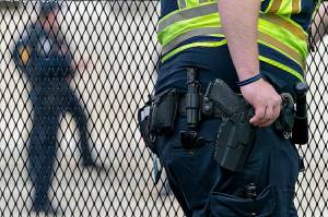 A Capitol Police Officer rests his hand near his gun as he works by the anti-scaling fencing outside the Supreme Court, Thursday, June 23, 2022, in Washington. (AP Photo/Jacquelyn Martin)