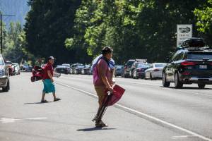 People wait for cars to pass by before crossing over US 2 to get to Eagle Falls on Wednesday, July 29, 2020 in Index, Wa. (Olivia Vanni / The Herald)
