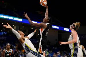 Dallas Wings' Kayla Thornton, front left, and Marina Mabrey, right, defend as Phoenix Mercury center Tina Charles (31) shoots in the second half of a WNBA basketball game, Friday, June 17, 2022, in Arlington, Texas. (AP Photo/Tony Gutierrez)
