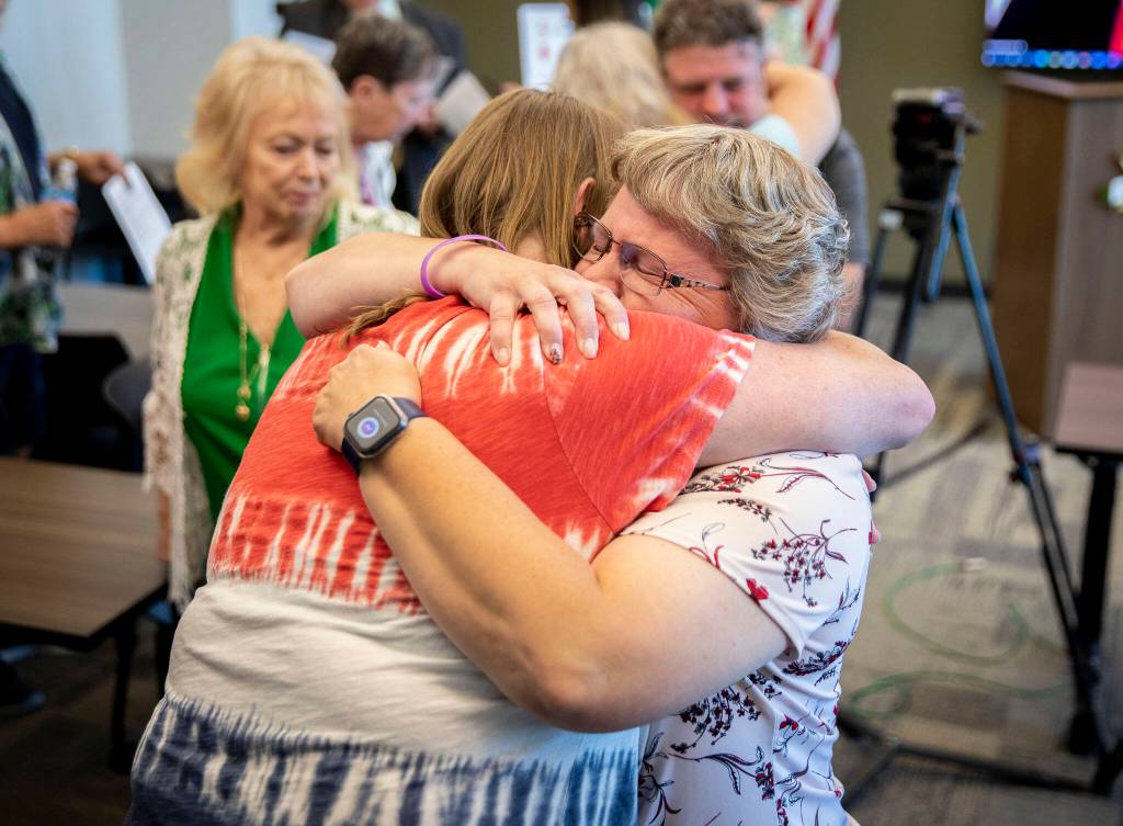 Melissa Johnson, right, hugs Kathy LaBounty, both friends of Michelle Koski, after the Snohomish County Sheriffs Office press conference announcing a suspect in Koskis 1990 cold case on Thursday in Everett. (Olivia Vanni / The Herald)
