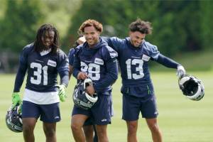 Seattle Seahawks running back DeeJay Dallas (31), wide receiver Cade Johnson (88), and wide receiver Aaron Fuller (13) walk off the field after NFL football practice Wednesday, June 8, 2022, in Renton, Wash. (AP Photo/Ted S. Warren)