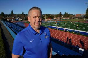 Joe Kennedy, a former assistant football coach at Bremerton High School in Bremerton, Wash., poses for a photo March 9, 2022, at the school's football field. After losing his coaching job for refusing to stop kneeling in prayer with players and spectators on the field immediately after football games, Kennedy will take his arguments before the U.S. Supreme Court on Monday, April 25, 2022, saying the Bremerton School District violated his First Amendment rights by refusing to let him continue praying at midfield after games. (AP Photo/Ted S. Warren)