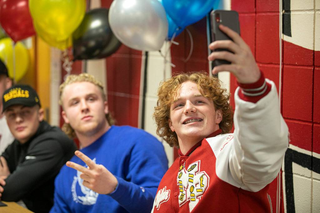 Dylan Carson takes a selfie with Nate Elwood and Jordan Velasquez during National Signing Day Wednesday, Feb. 2, 2022, at Marysville Pilchuck High School in Marysville, Washington. (Ryan Berry / The Herald)