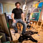 Lee Oskar and his dog Tex inside his art studio in his Everett home. (Olivia Vanni / The Herald)