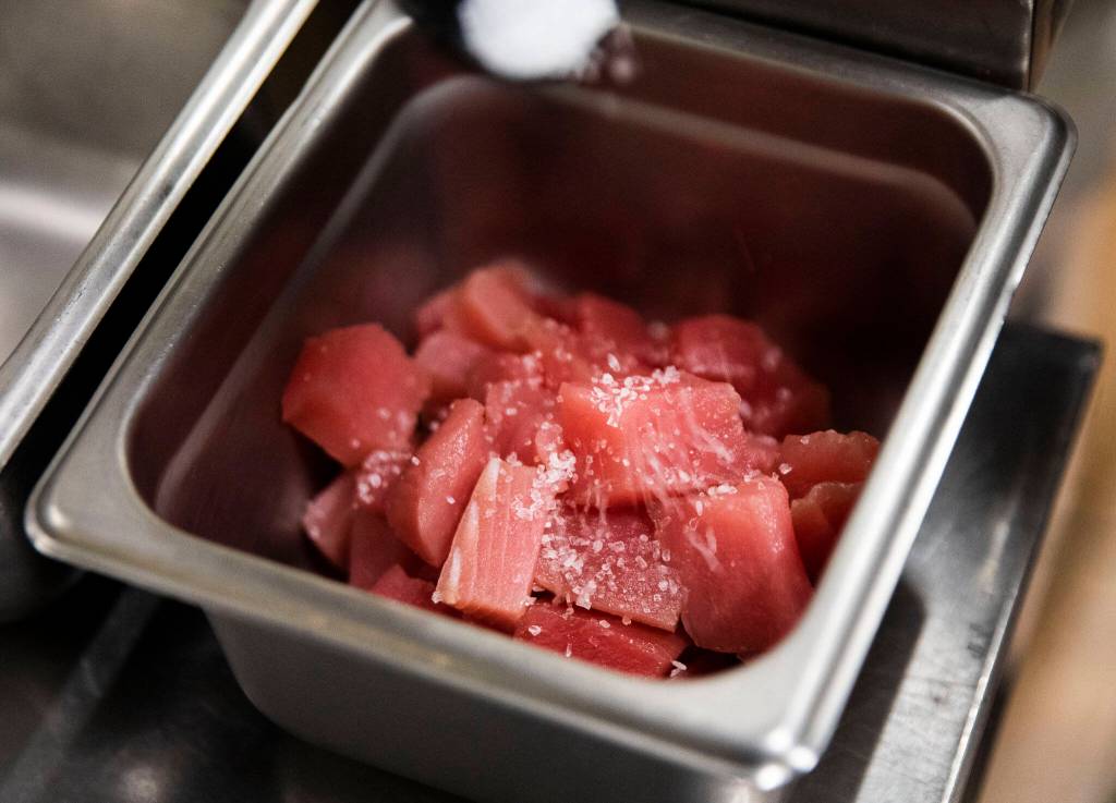 Psalms Jodi Moe seasons tuna with Hawaiian salt. (Olivia Vanni / The Herald)