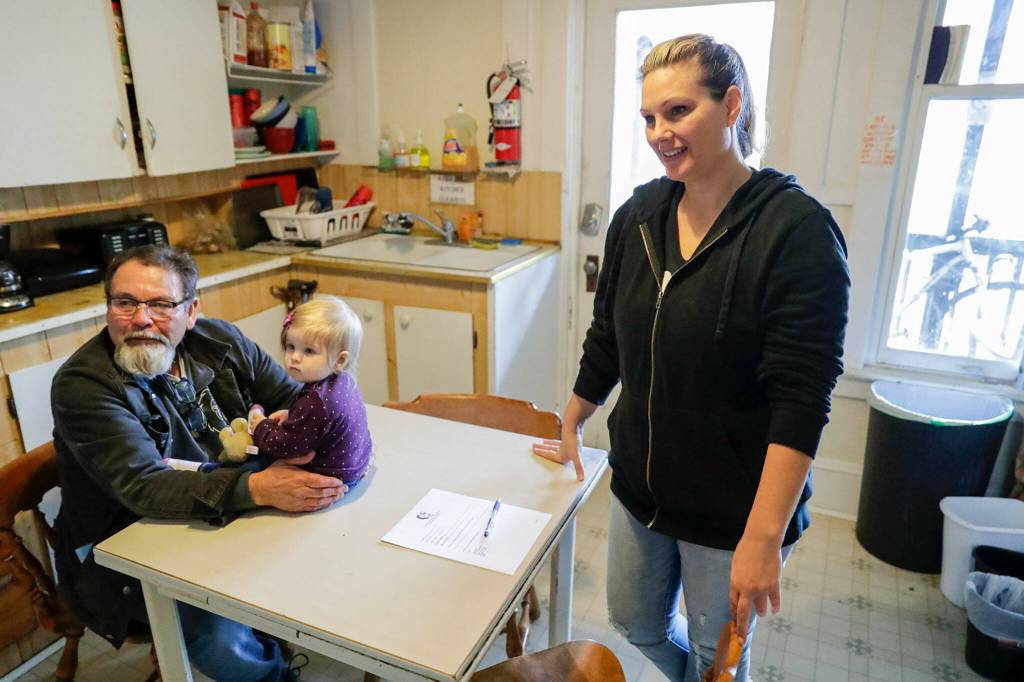 Mike Kersey with Aiya Moore, daughter of Christina Anderson, right, talks about the condition of Nicks Place in Everett in June. (Kevin Clark / The Herald)