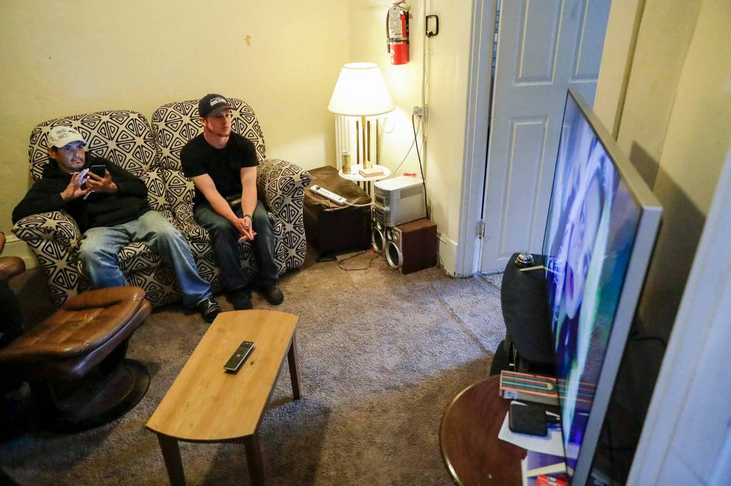 Residents watch a show in the common room of Nicks Place in Everett in June. (Kevin Clark / The Herald)