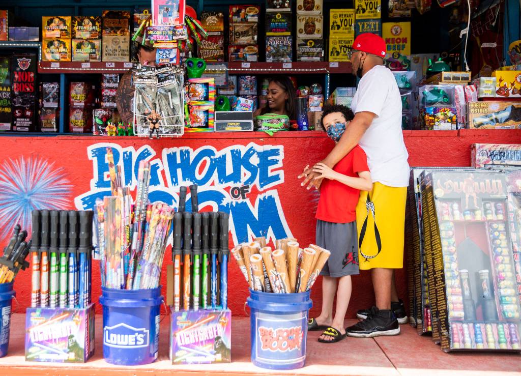 Chris Rutland and son Julian buy fireworks from the Big House of Boom stall at Boom City on Thursday in Tulalip. (Olivia Vanni / The Herald)