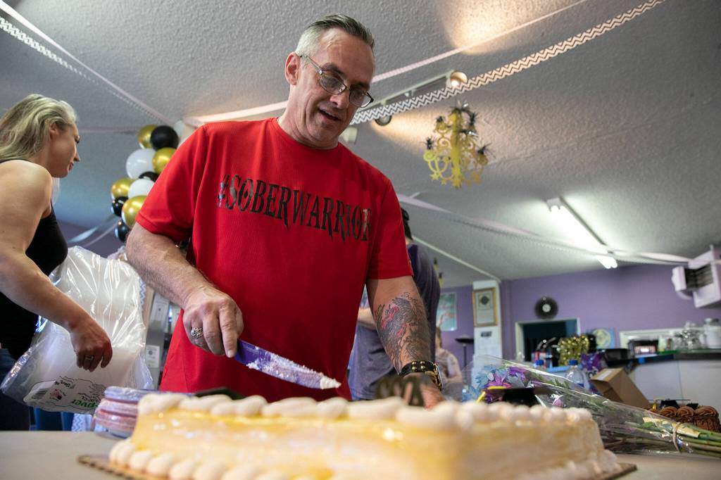 Second Chances Jason Cockburn cuts the cake during a Second Chance Foundation graduation party on June 26, in Everett. (Ryan Berry / The Herald)