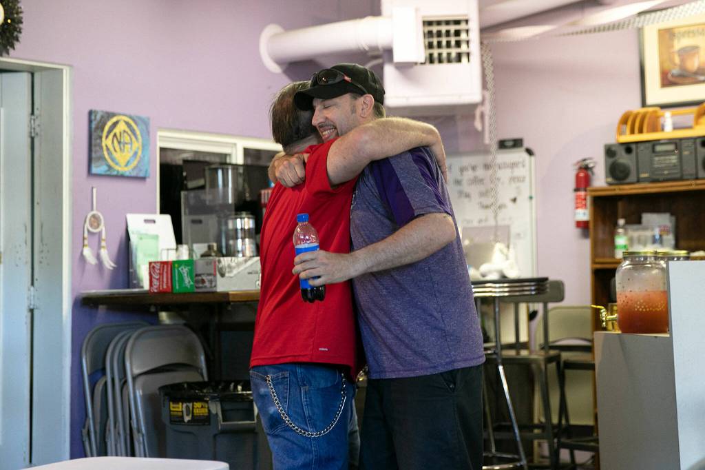 Jason Cockburn and Kyle Von Stroberg hug during a Second Chance Foundation graduation party on June 26, in Everett. (Ryan Berry / The Herald)