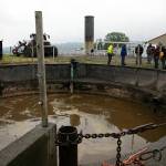 A group gathers near a blending pit, which is where cow waste and other biodegradable material begins its journey towards becoming energy in a digester on June 17 in Monroe. (Ryan Berry / The Herald)