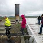 People walk off of the top of the anaerobic digester at Werkhoven Dairy while touring the facility on June 17 in Monroe. (Ryan Berry / The Herald)