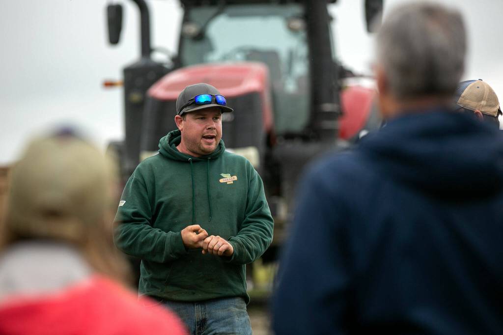 Jon Van Nieuwenhuyzen of Werkhoven Dairy speaks to a group of visitors while discussing the Qualco Energy anaerobic digester the dairy uses on June 17 in Monroe. (Ryan Berry / The Herald)