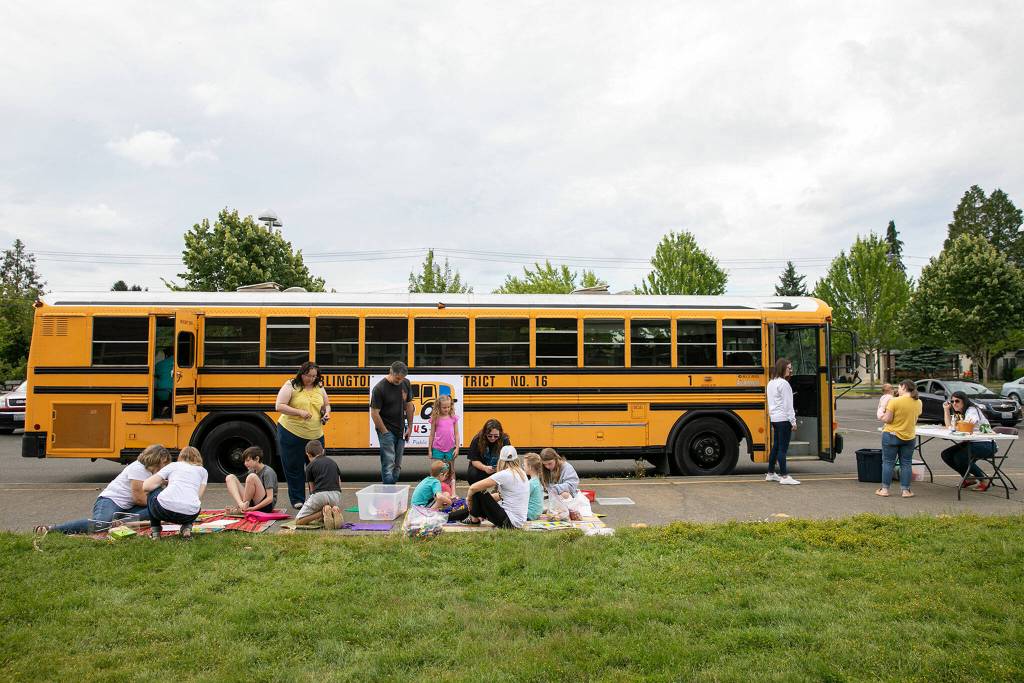 Families begin to show up and hang out at the Cool Bus on July 6, at Presidents Elementary School in Arlington. (Ryan Berry / The Herald)