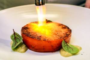 Tomato is charred by Joel Childs Thursday afternoon at The Chef Behind The Curtain in Snohomish, Washington on June 30, 2022. (Kevin Clark / The Herald)
