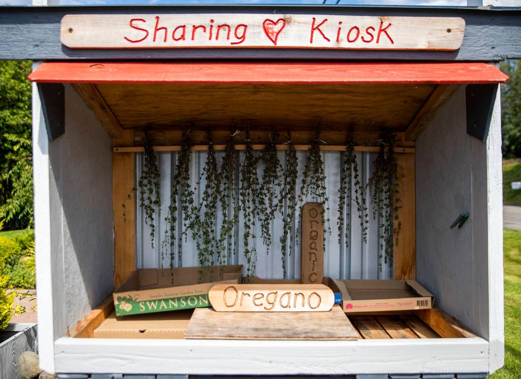 Dried herbs hang in a “sharing kiosk” at a Mukilteo garden-quilt tour home on Thursday, July 7, 2022. (Olivia Vanni / The Herald)