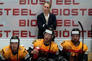 FILE - Germany's assistant coach Jessica Campbell stands behind players on the German bench during the group A Hockey World Championship match between France and Germany in Helsinki, Finland, Monday May 16, 2022. The Coachella Valley Firebirds have hired Jessica Campbell as the American Hockey League’s first female assistant coach. (AP Photo/Martin Meissner, File)