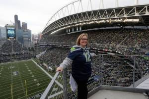 Seattle Seahawks owner Jody Allen stands on a balcony at CenturyLink Field after she raised the 12th man flag before the team's NFL football game against the Los Angeles Rams, Thursday, Oct. 3, 2019, in Seattle. (AP Photo/Stephen Brashear)