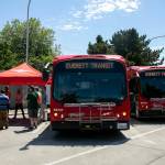 Officials gather outside two Everett Transit electric buses to discuss the new BattGenie system June 27, at the bus facility. (Ryan Berry / The Herald)