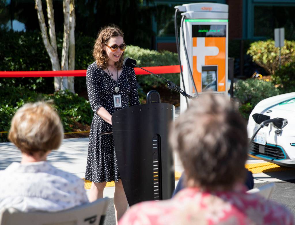 Project manager Suzy Oversvee speaks at the ribbon cutting for two EV charging stations outside of PUD headquarters on Wednesday, in Everett. (Olivia Vanni / The Herald)