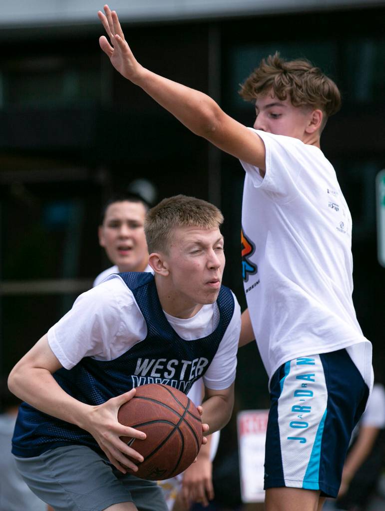 Two teams face off during Everett 3on3 Saturday, July 9, 2022, in downtown Everett, Washington. (Ryan Berry / The Herald)