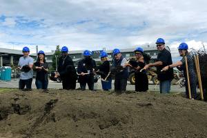 Port of Everett and City of Everett officials hoist their shovels at a ceremonial ground breaking June 7, 2022 at Port Gardner Landing. Two new buildings will house Woods Coffee and Sound 2 Summit Brewery. (Janice Podsada/The Herald)