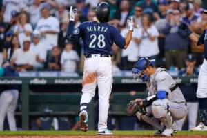 Seattle Mariners' Eugenio Suarez crosses the plate next to Toronto Blue Jays catcher Gabriel Moreno after hitting a solo home run during the fifth inning of a baseball game Thursday, July 7, 2022, in Seattle. (AP Photo/Ted S. Warren)