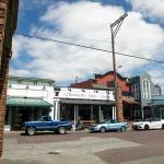 Vehicles are parked in front boutique-style businesses on the brick road portion of 270th Street on Friday, July 22, 2022, in Historic West Downtown in Stanwood, Washington. (Ryan Berry / The Herald)