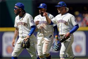 From left, Seattle Mariners' J.P. Crawford, Carlos Santana, and Eugenio Suarez react as they walk off the field after a baseball game against the Toronto Blue Jays, Sunday, July 10, 2022, in Seattle. The Mariners won 6-5. (AP Photo/Ted S. Warren)