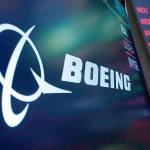 FILE - The logo for Boeing appears on a screen above a trading post on the floor of the New York Stock Exchange, Tuesday, July 13, 2021. Boeing is reporting a money-losing quarter as both its civilian-airplane division and the defense business are struggling. Boeing said Wednesday, April 27, 2022,  that it lost $1.24 billion in the first quarter and took large write-downs for several programs.  (AP Photo/Richard Drew, file)