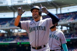Seattle Mariners' Eugenio Suarez reacts after hitting a three-run home run in the first inning of the first game of a baseball doubleheader against the Washington Nationals, Wednesday, July 13, 2022, in Washington. (AP Photo/Patrick Semansky)